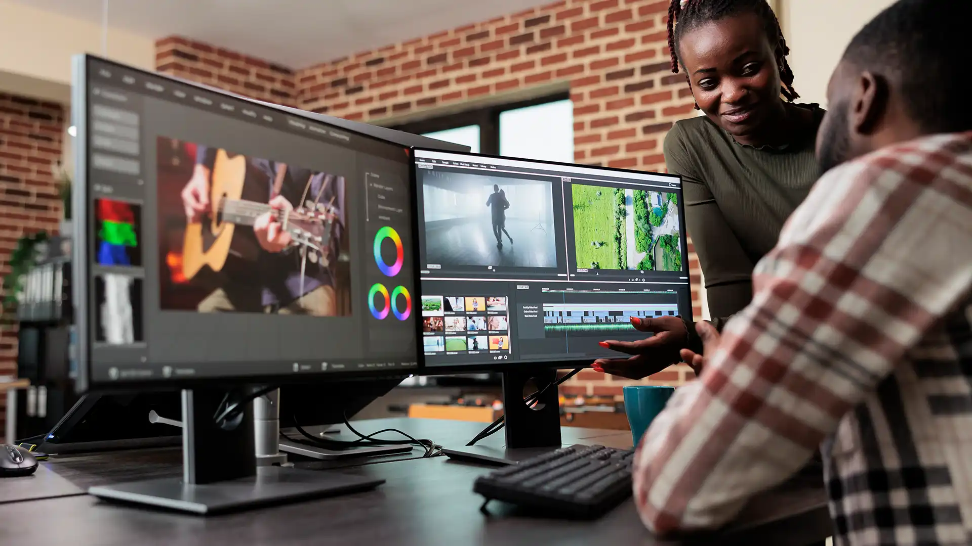 Two designers refining digital artwork together at a workstation