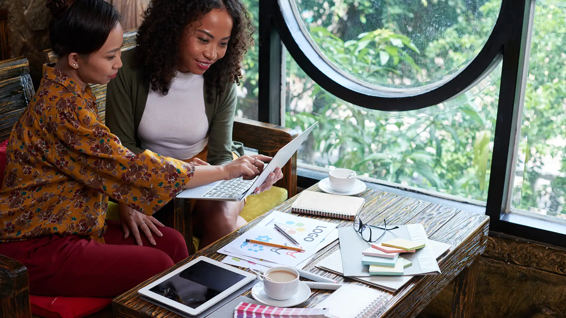 Creative entrepreneurs collaborating on brand guidelines using a laptop